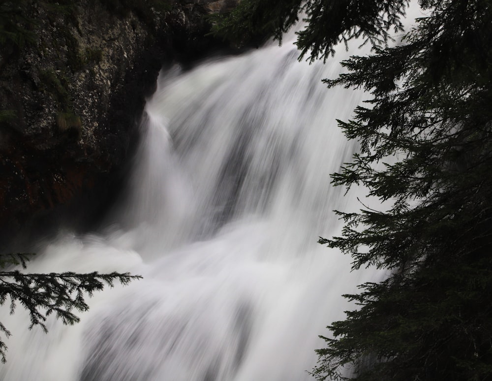 a waterfall is seen through the trees