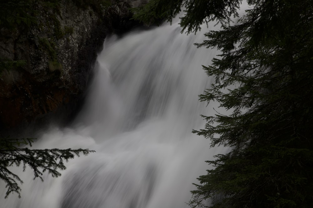 a waterfall is seen through the trees