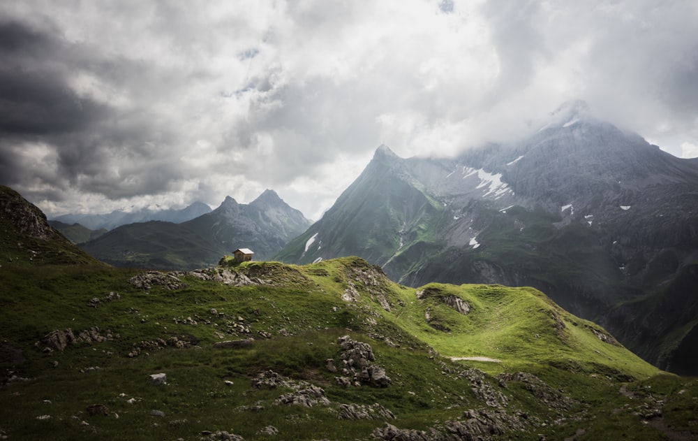 une colline herbeuse avec une maison au sommet