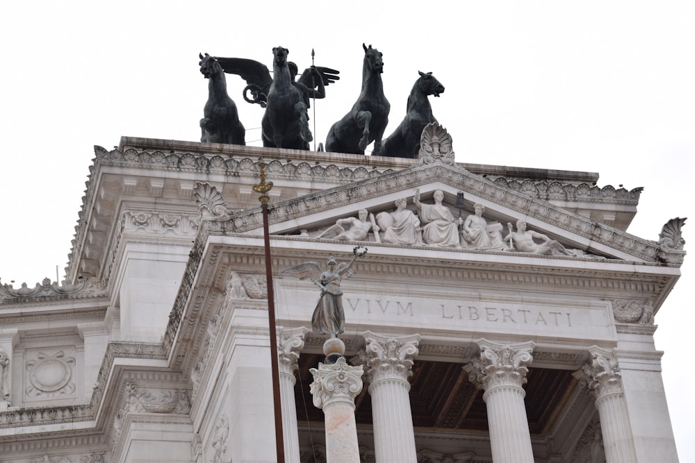 un alto edificio con statue in cima