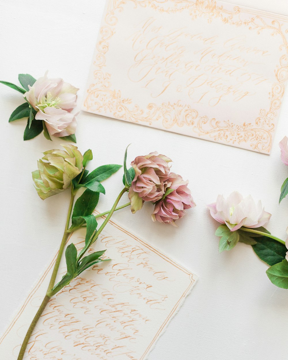 three flowers and a card on a table