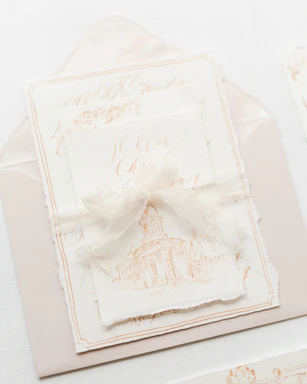 Close-up of a beautifully crafted elegant invitation with delicate embossing and gold foil accents on a soft textured paper.