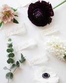 a white table topped with flowers and place cards