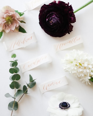 a white table topped with flowers and place cards