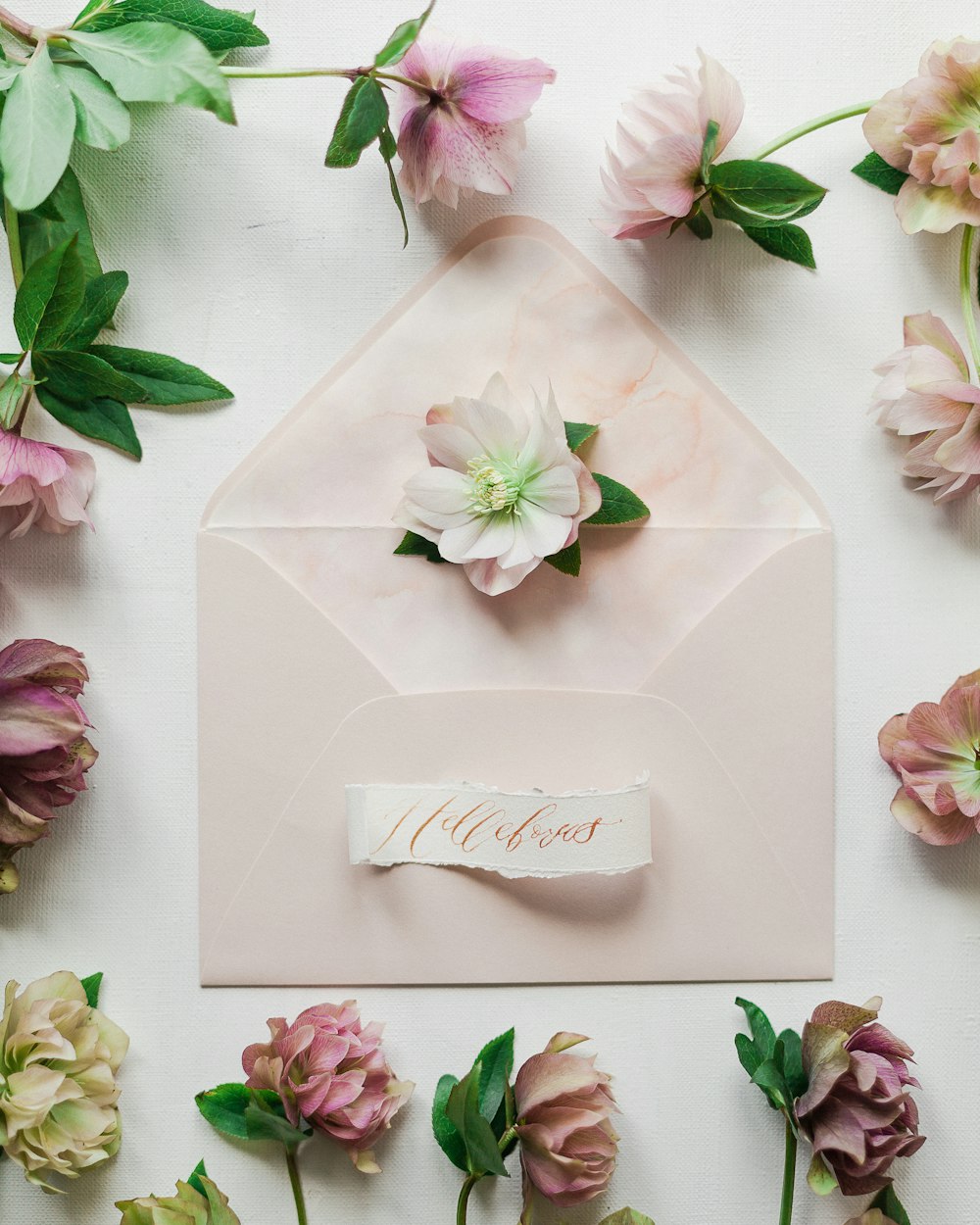 a pink envelope with a flower on top of it