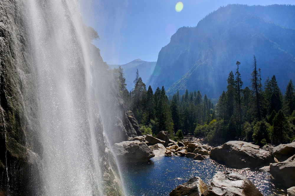 a large waterfall with a lake below it