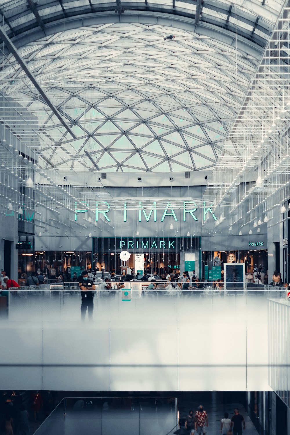 the interior of a shopping mall with people walking around