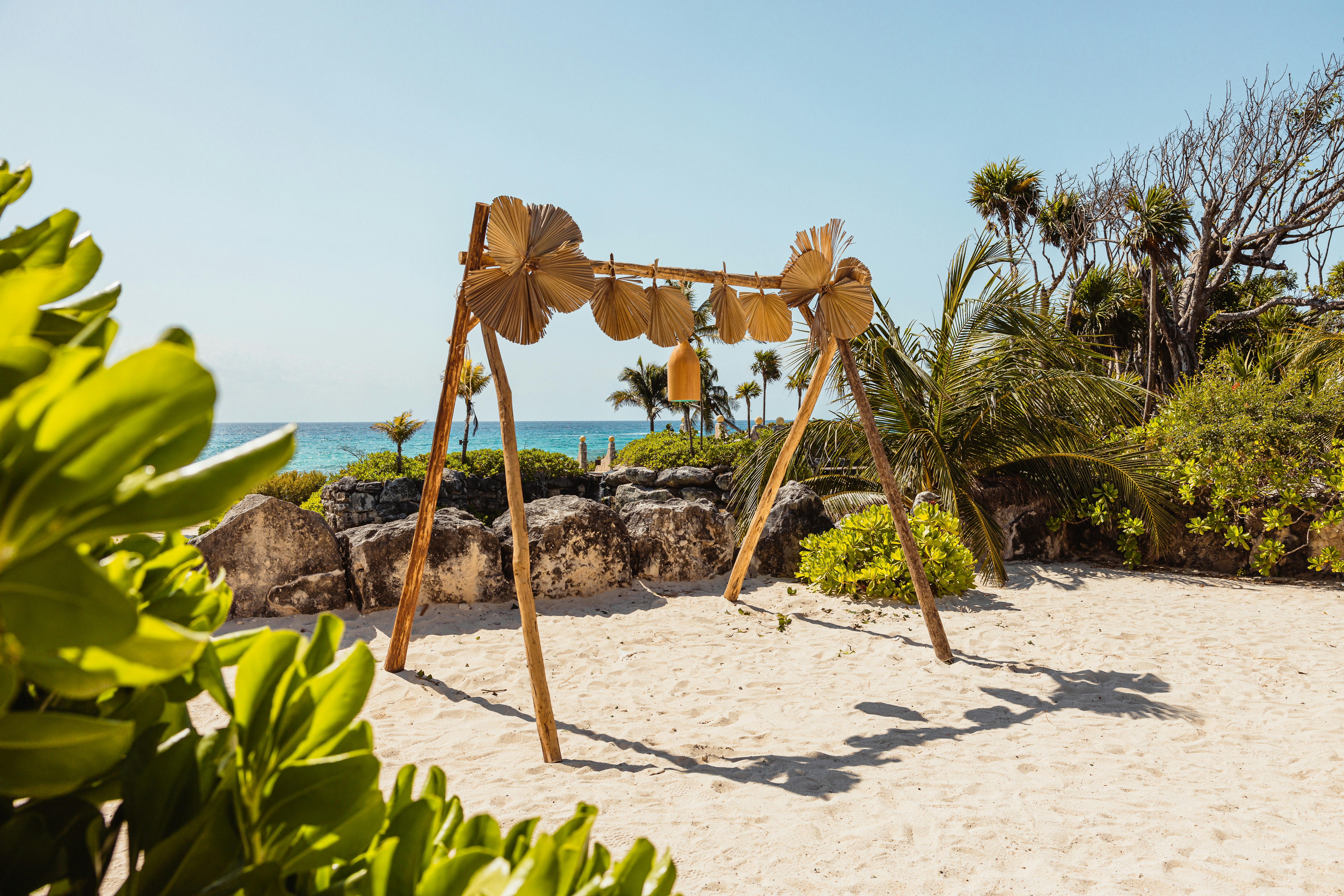 a wooden swing set sitting on top of a sandy beach