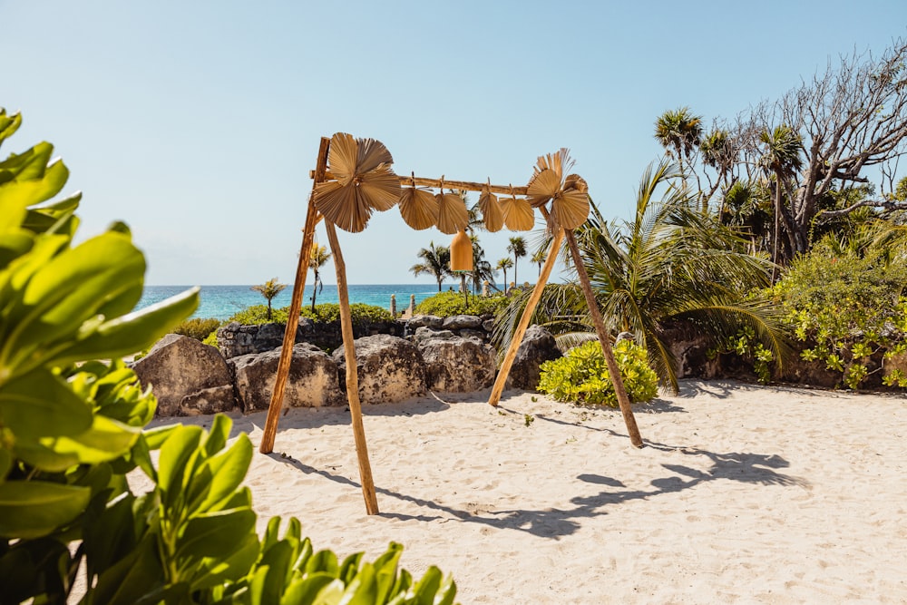 a wooden swing set sitting on top of a sandy beach