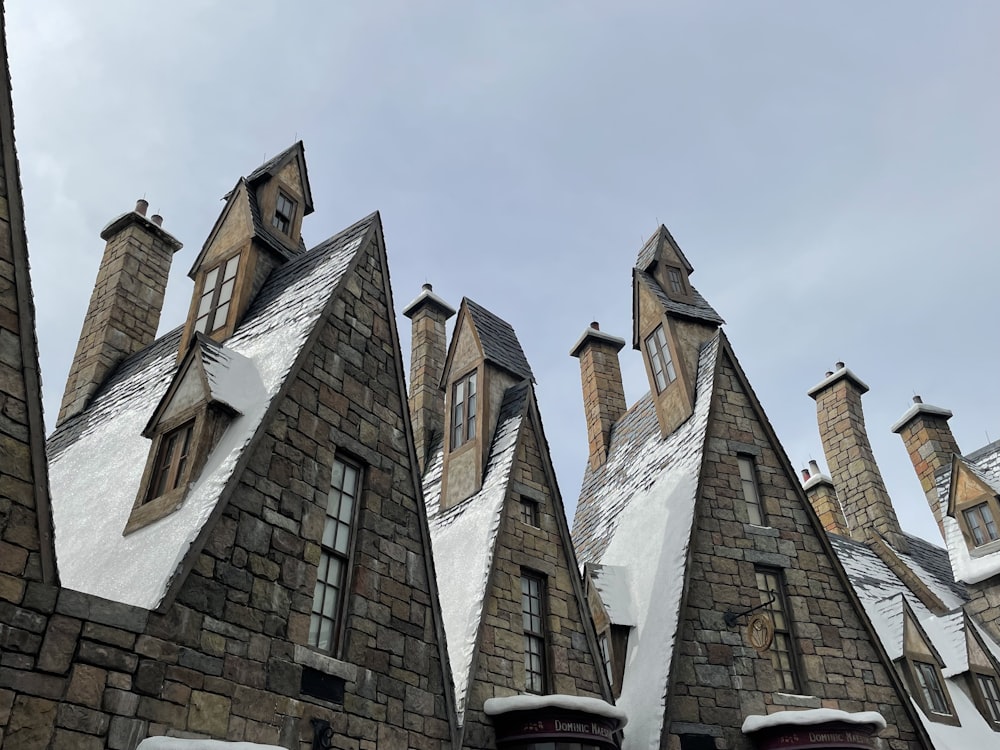 a row of stone buildings with snow on the roof