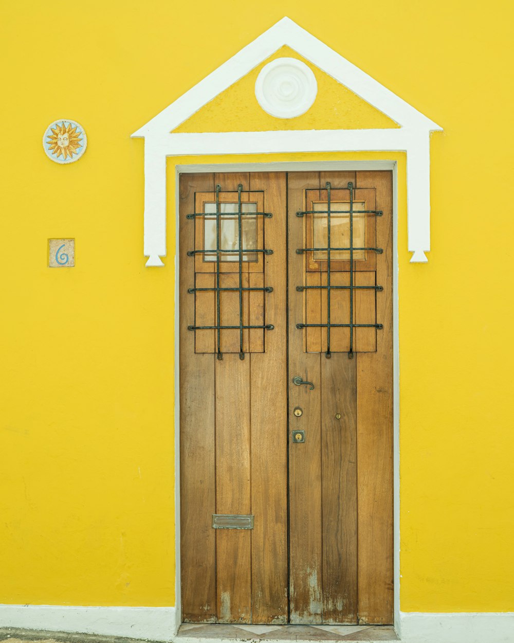 a yellow building with a wooden door and window