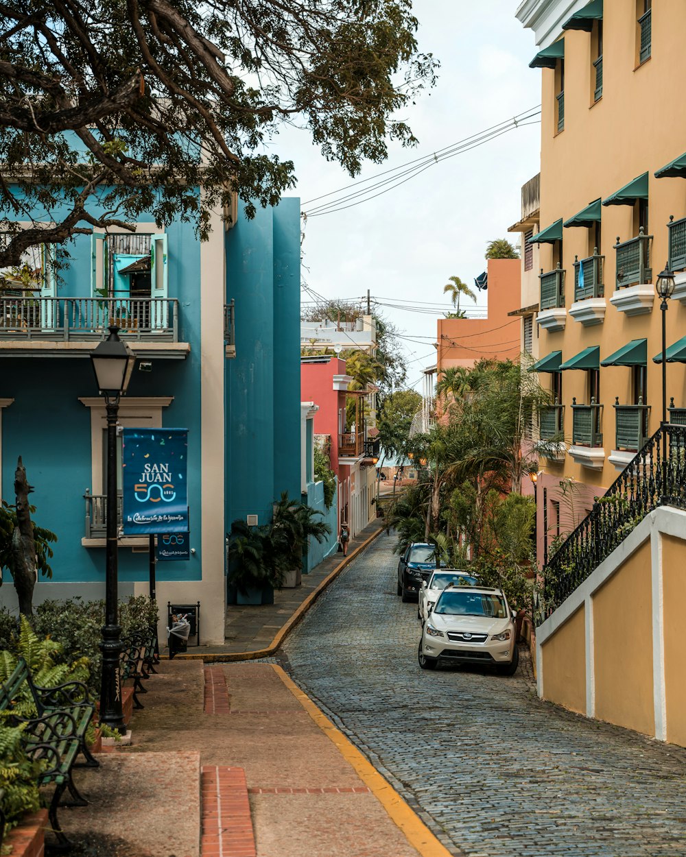 a car is parked on a cobblestone street