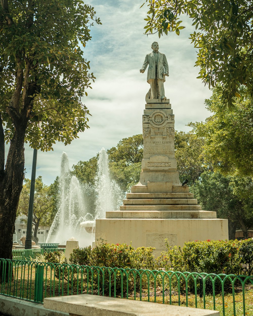 a statue of a man in front of a fountain