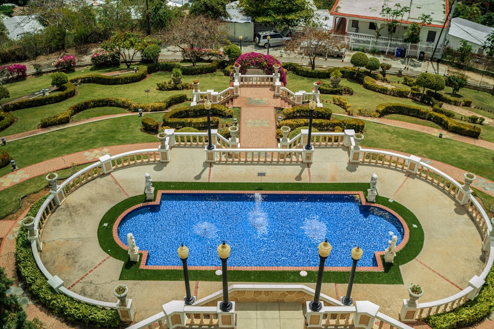 an aerial view of a pool surrounded by landscaping