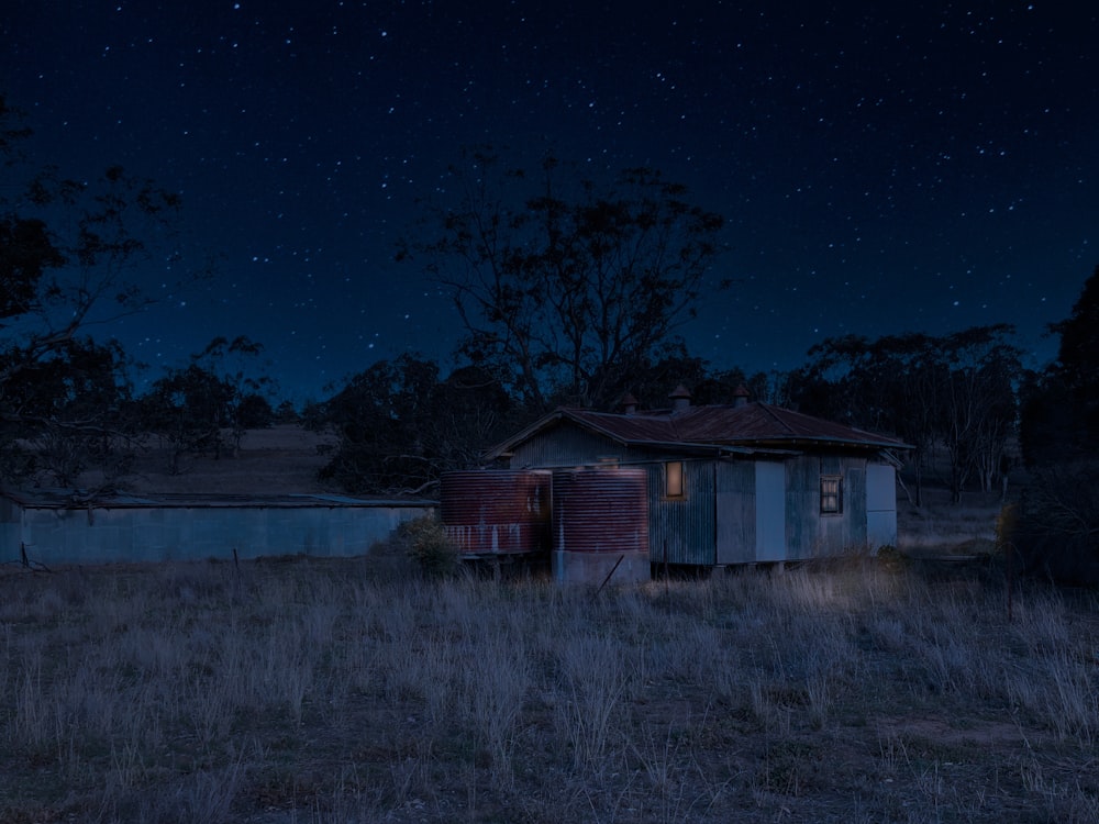an old run down shack in a field at night