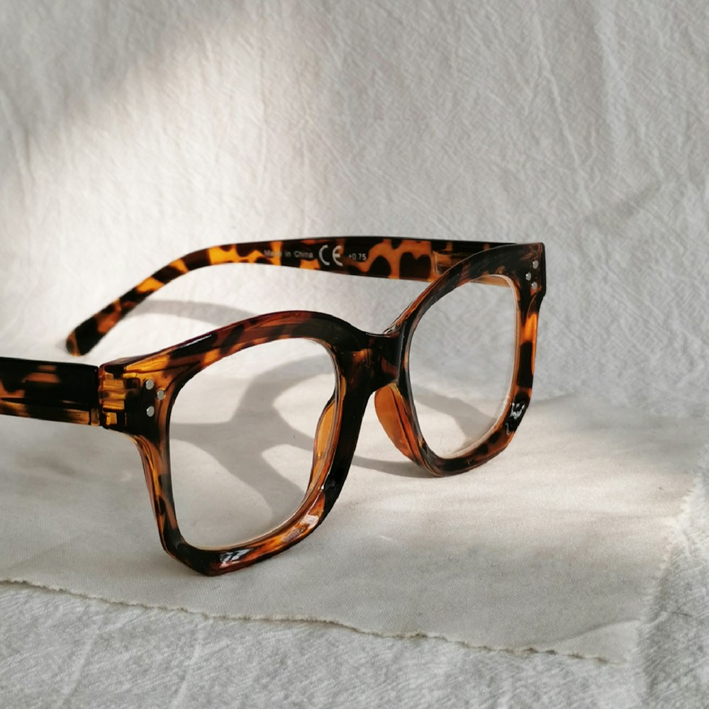 a pair of glasses sitting on top of a white sheet