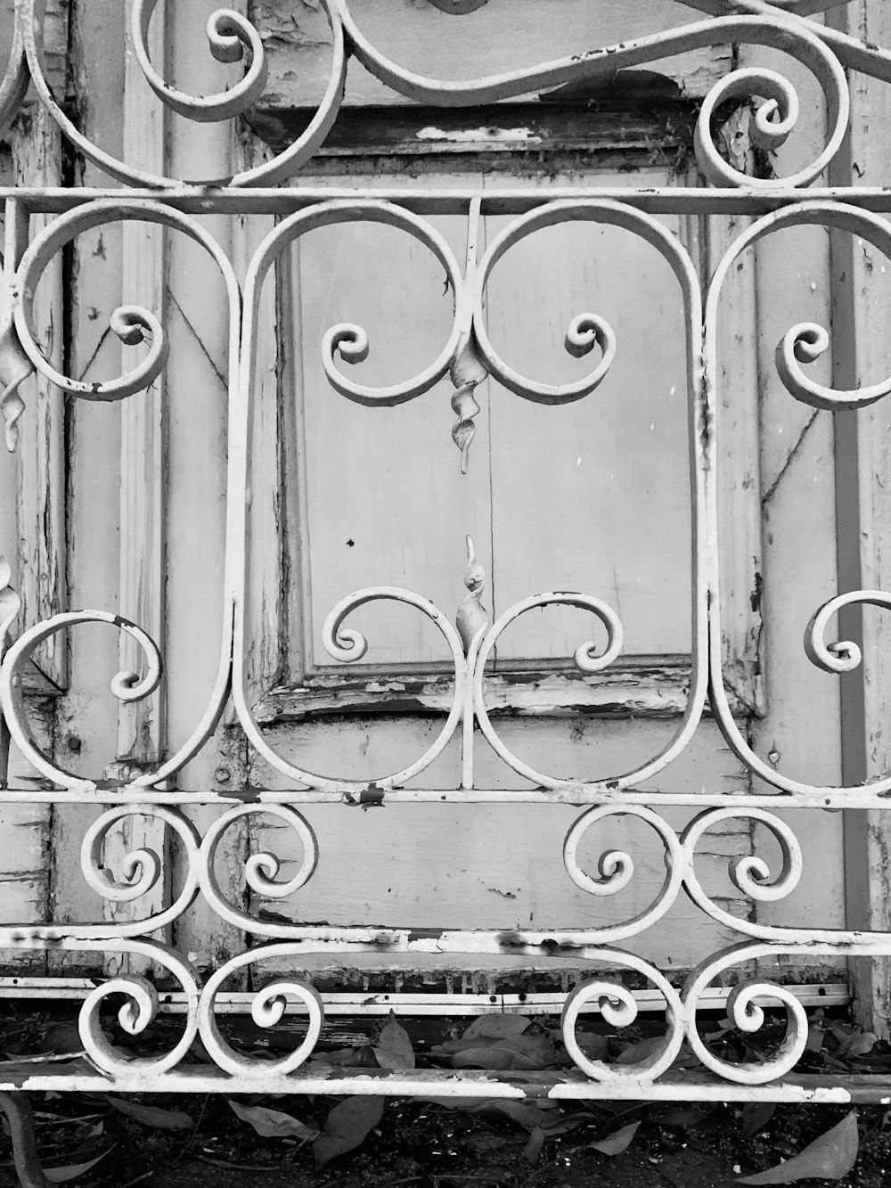 a black and white photo of a window with iron bars