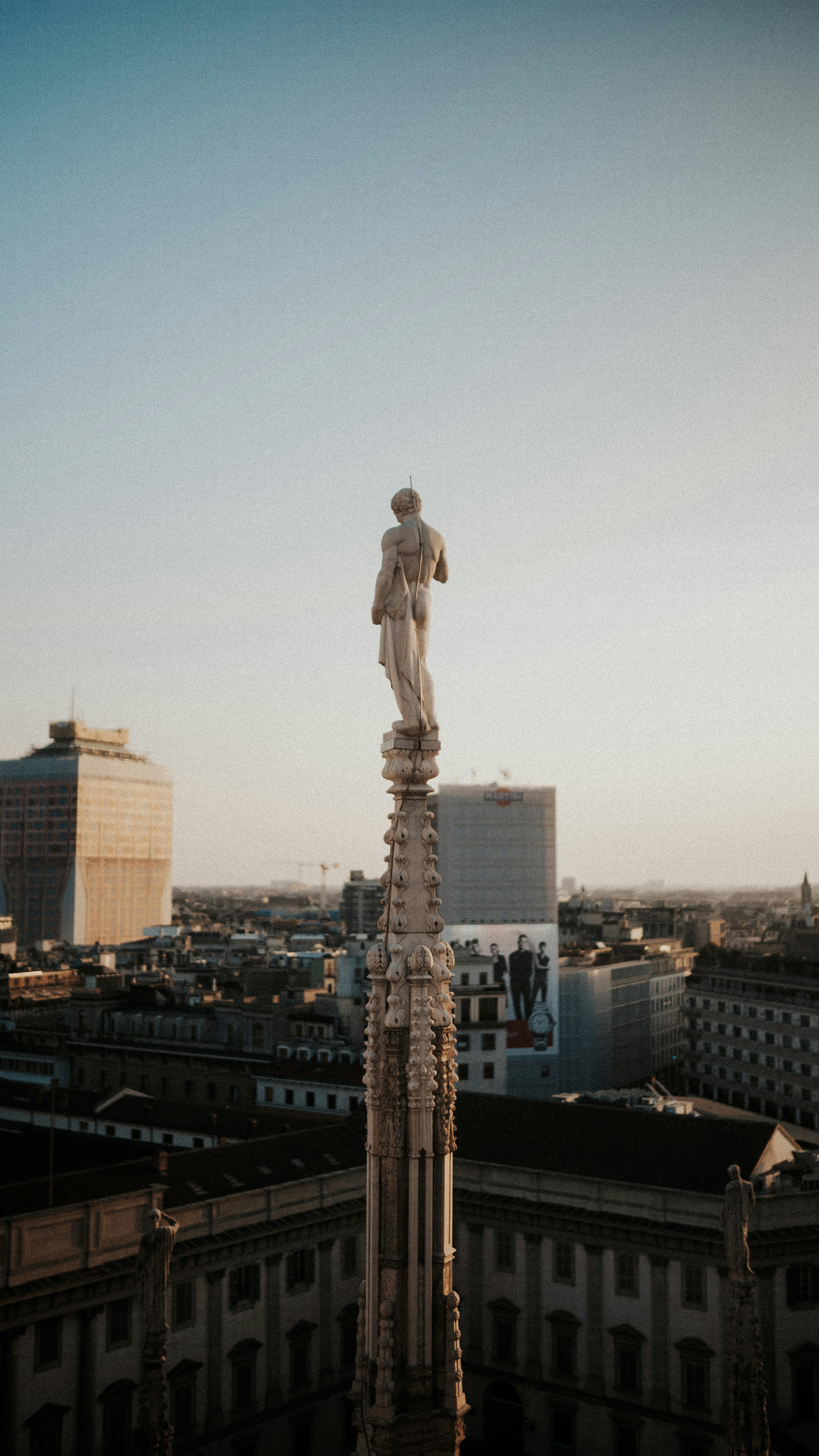 Una statua sulla cima di un edificio in una città