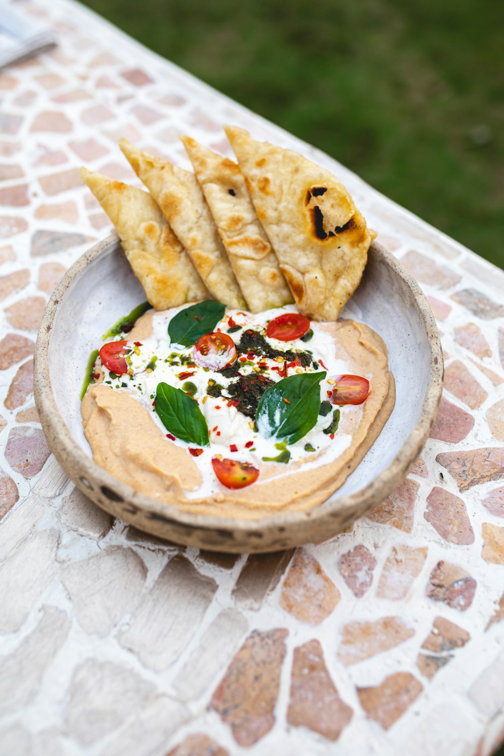 a bowl of hummus and pita chips on a table