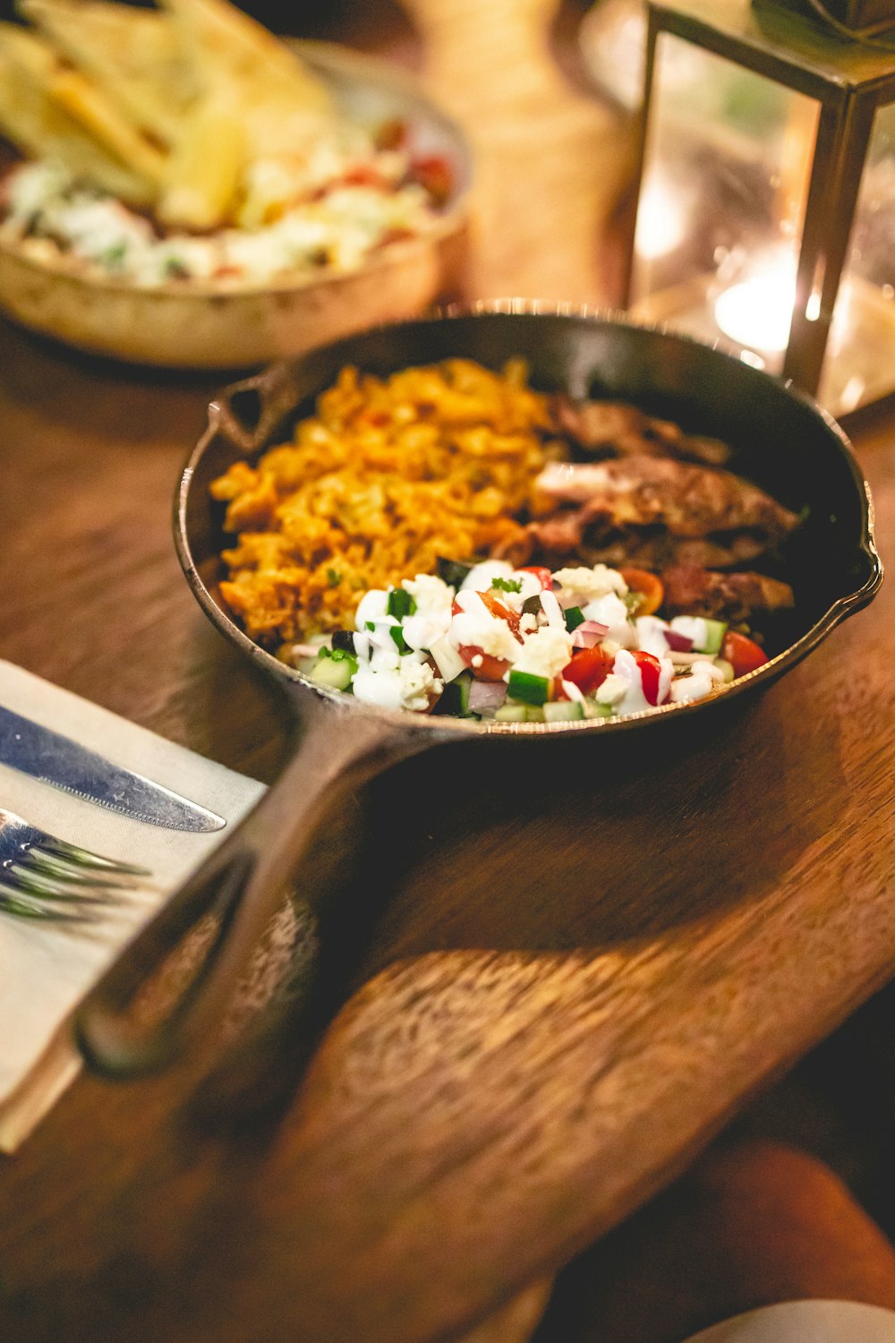 a wooden table topped with a pan filled with food