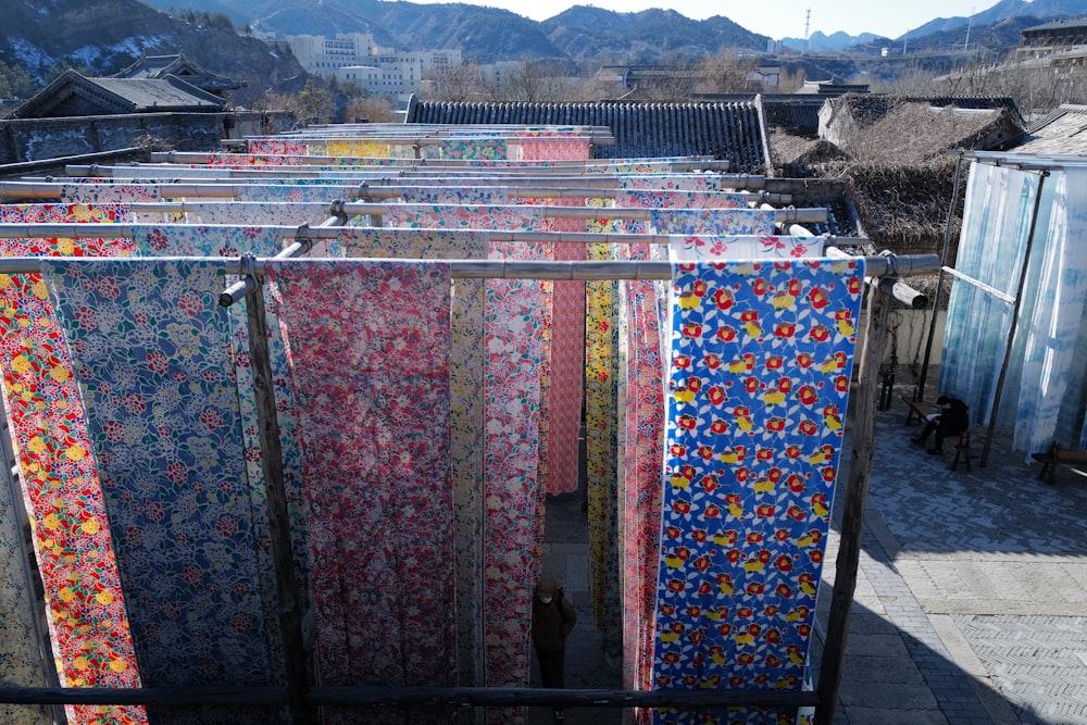 a bunch of colorful cloths hanging from a metal rack