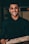 a man in a black shirt is holding a pizza
