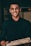 a man in a black shirt is holding a pizza