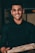 a man in a black shirt is holding a pizza