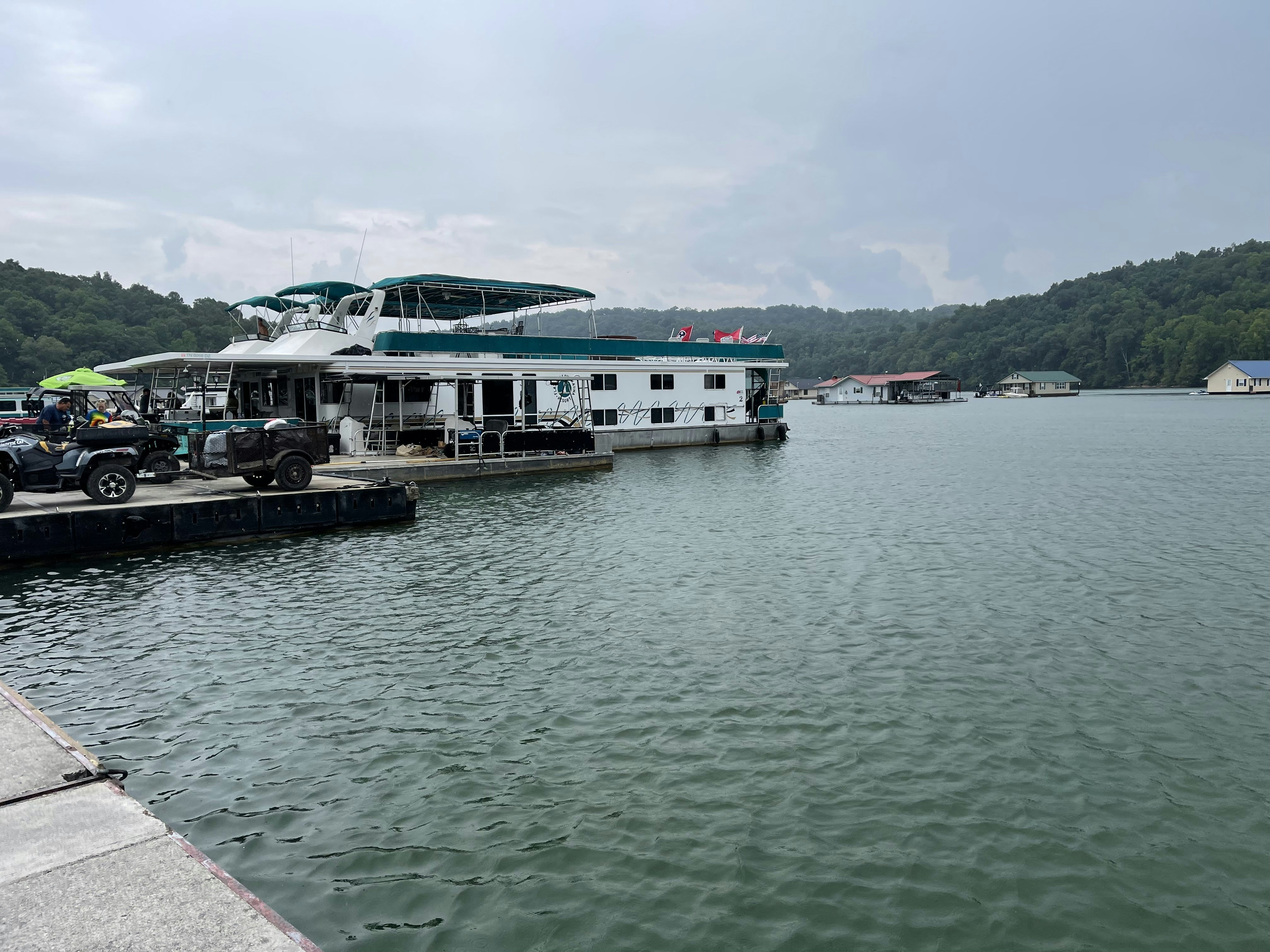 a boat docked at a pier with cars parked on it