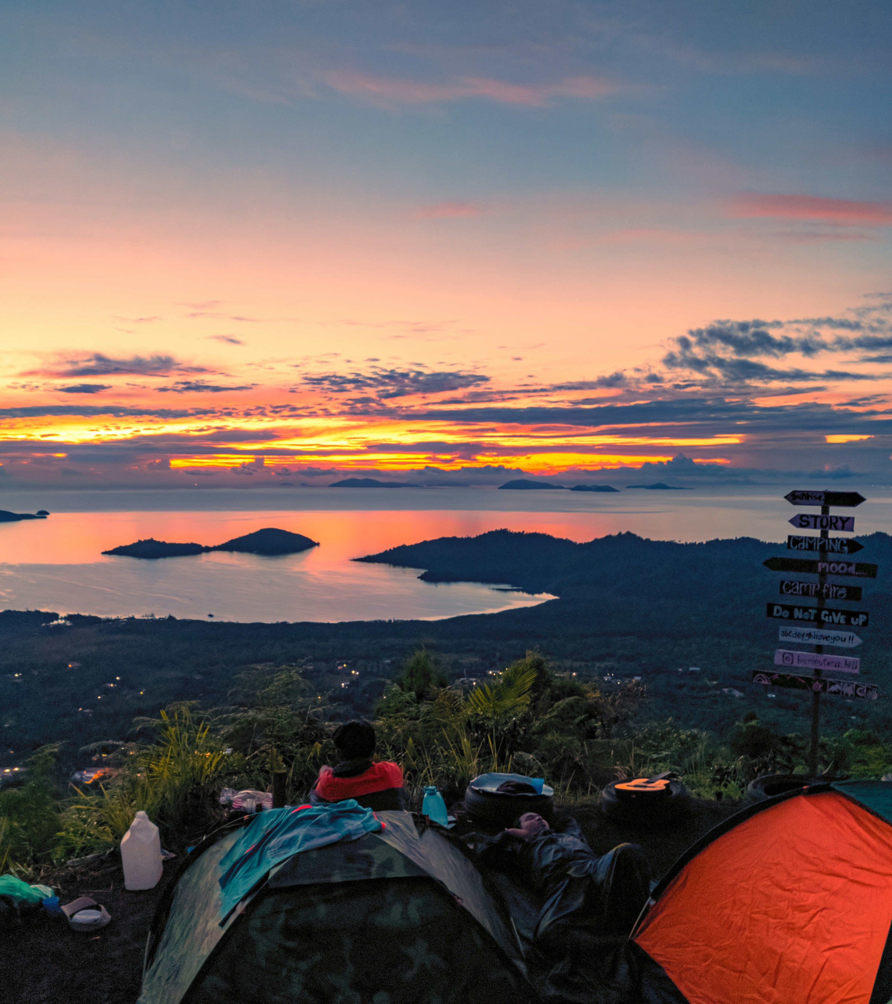 A couple of tents sitting on top of a lush green hillside photo – Free ...