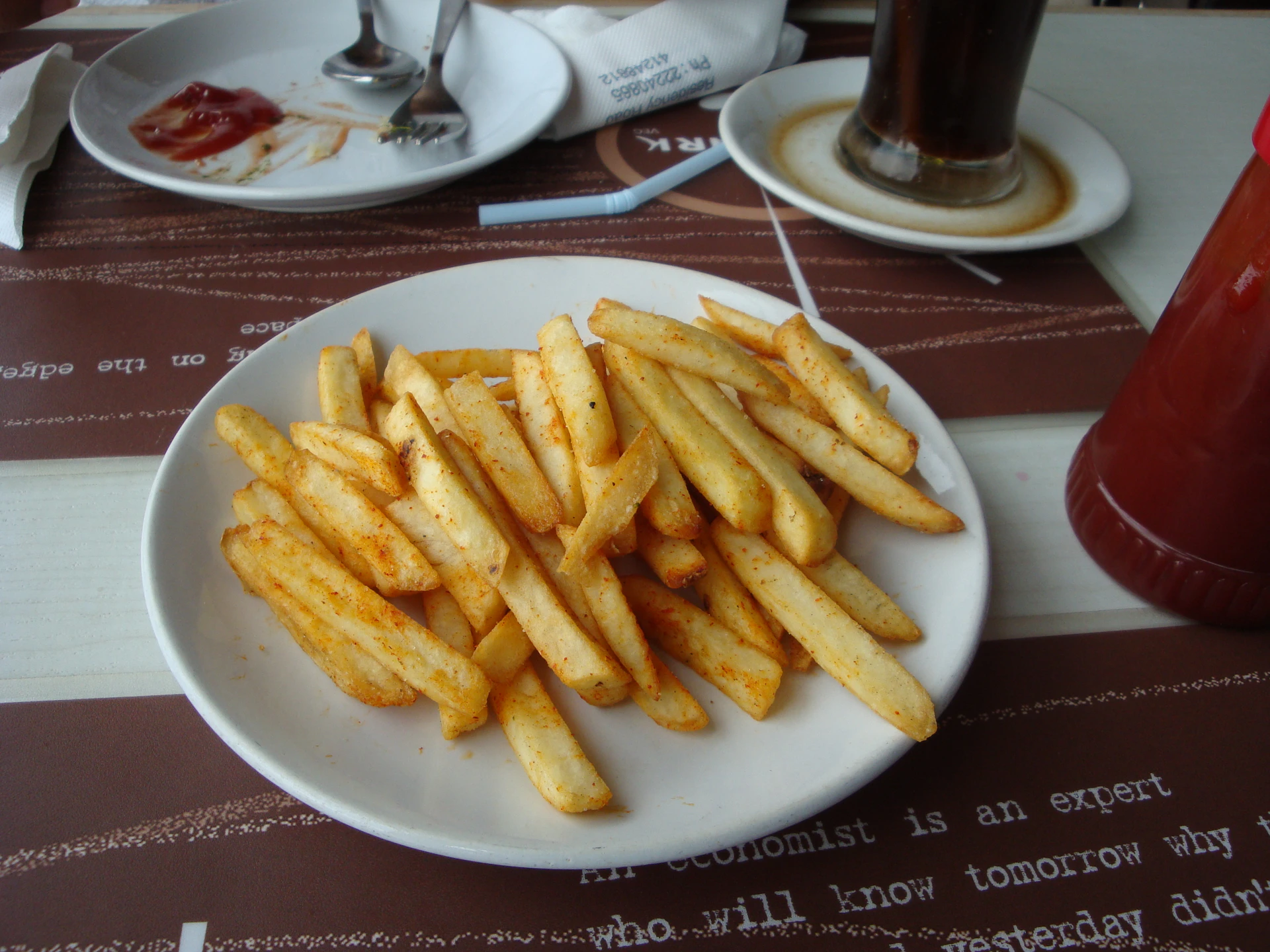 a white plate topped with french fries on top of a table