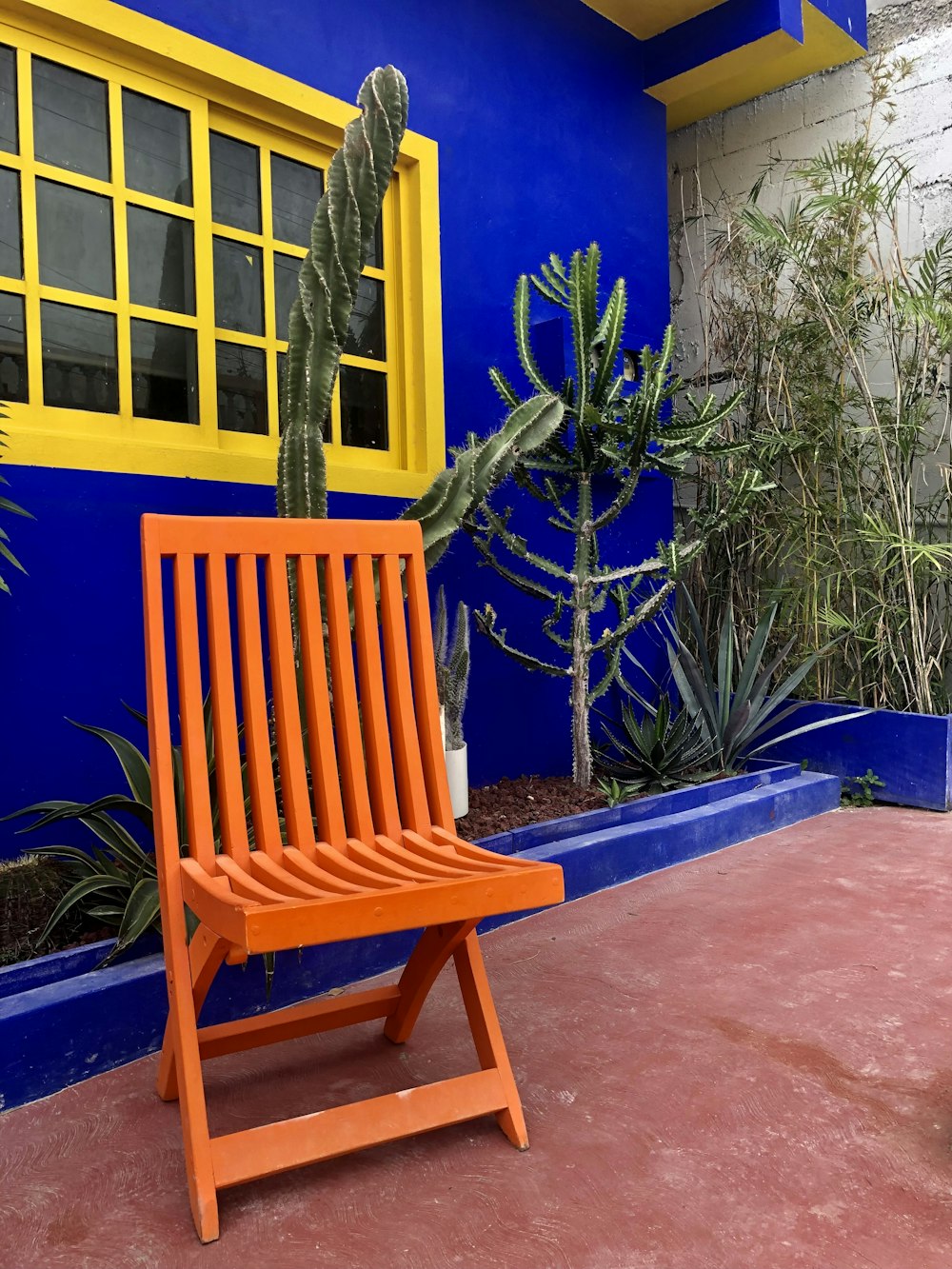 a wooden chair sitting in front of a blue building