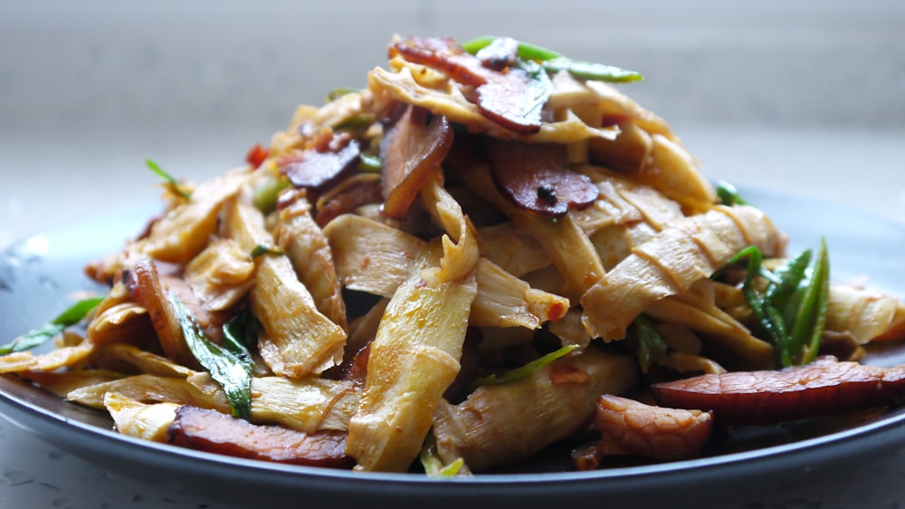 a plate of pasta with meat and vegetables