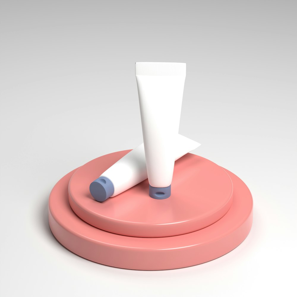 a pink object with a white tube on top of it
