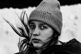 a woman with long hair wearing a beanie