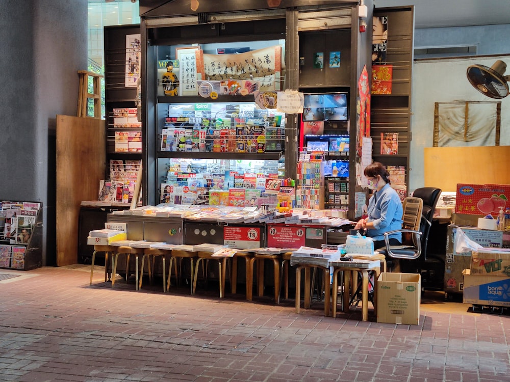 a woman sitting at a table in front of a store