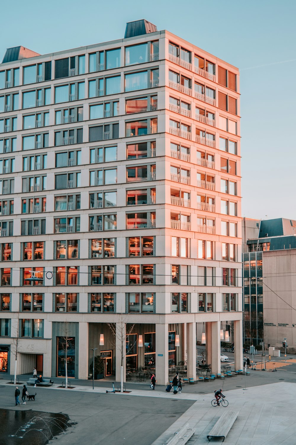 a tall building with lots of windows next to a parking lot