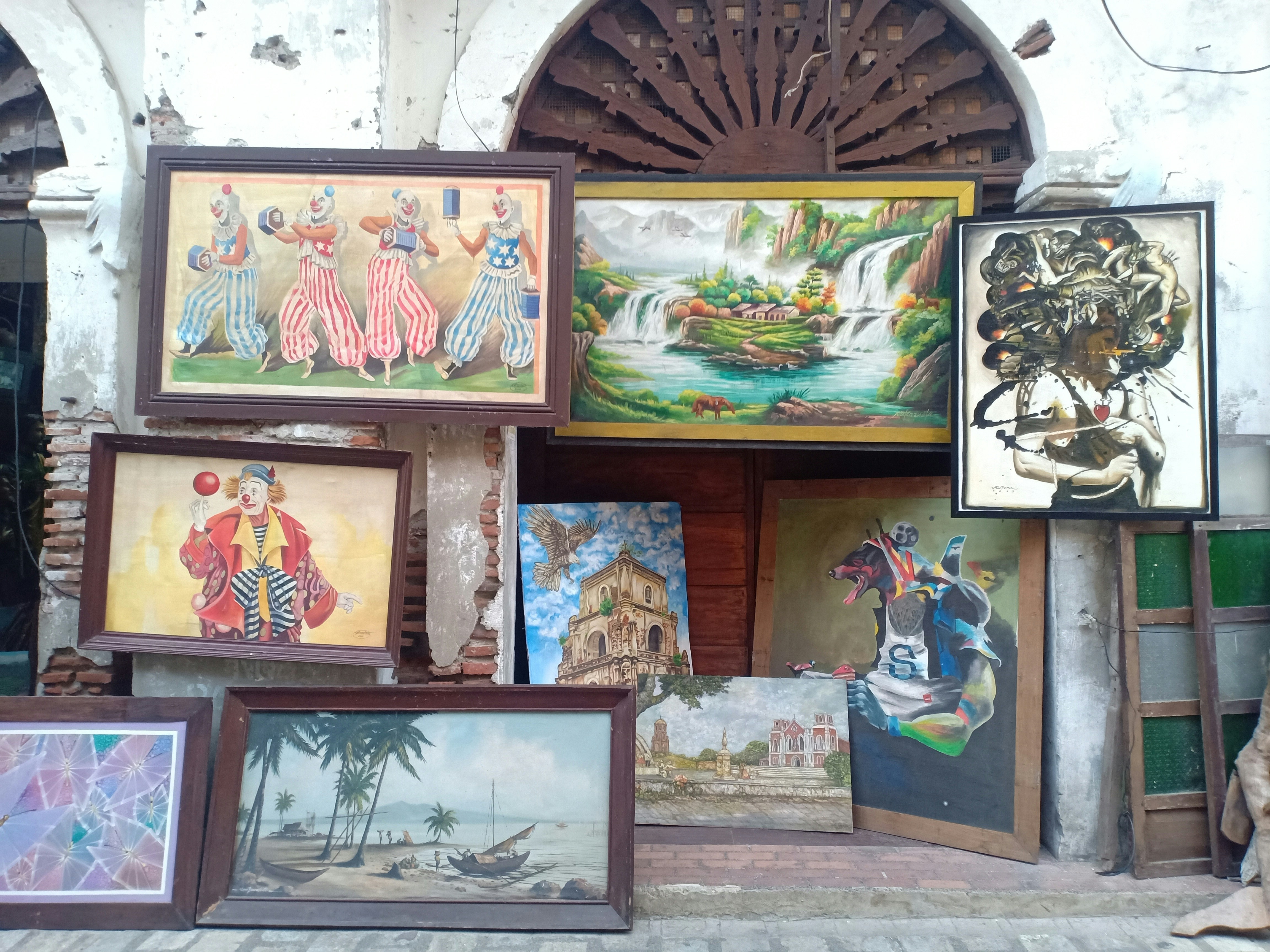 a number of paintings on a wall near one another