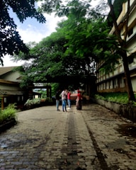 A team of environmental engineers discussing plans outdoors near green trees.