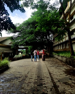 Students from diverse backgrounds engaged in a lively interfaith dialogue circle outdoors, surrounded by greenery.