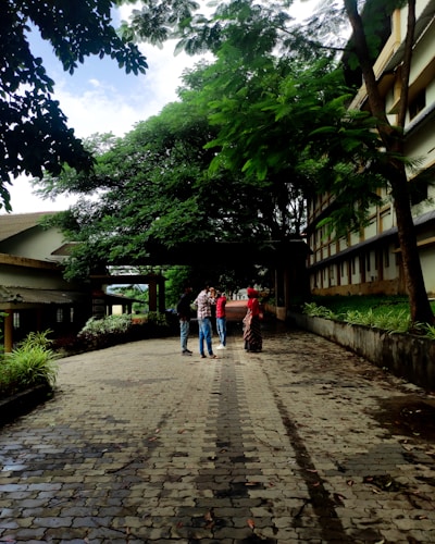 Students from diverse backgrounds engaged in a lively interfaith dialogue circle outdoors, surrounded by greenery.