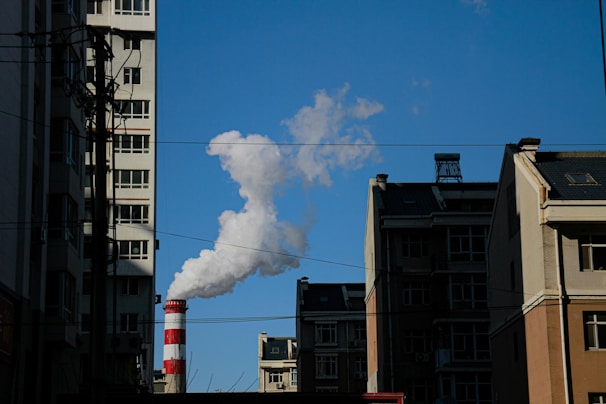 a smokestack emits from a building in a city