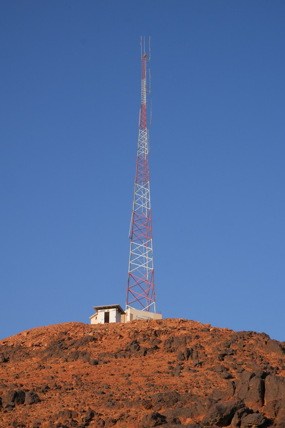 a radio tower on top of a rocky hill