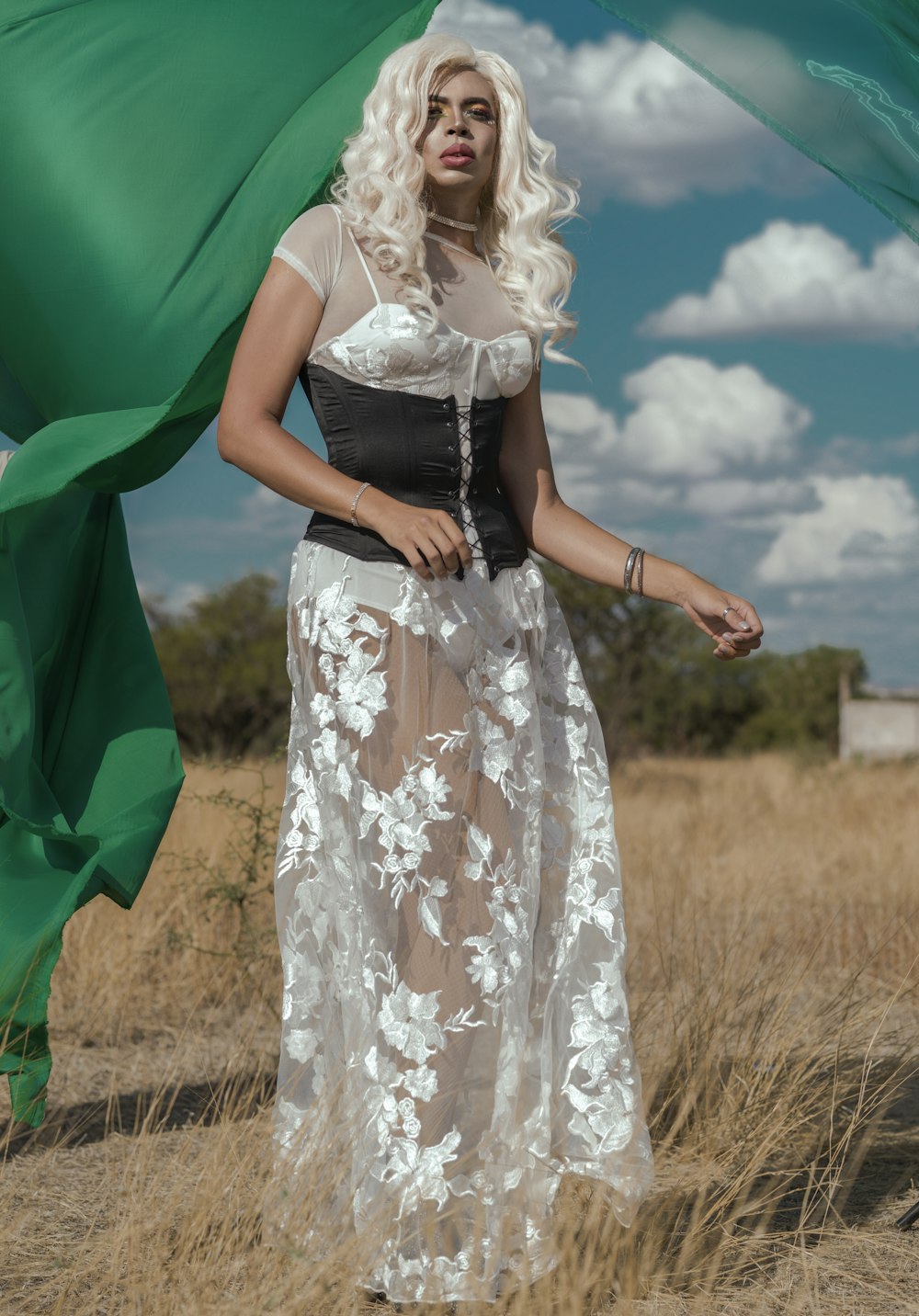 a woman in a white and black dress standing in a field