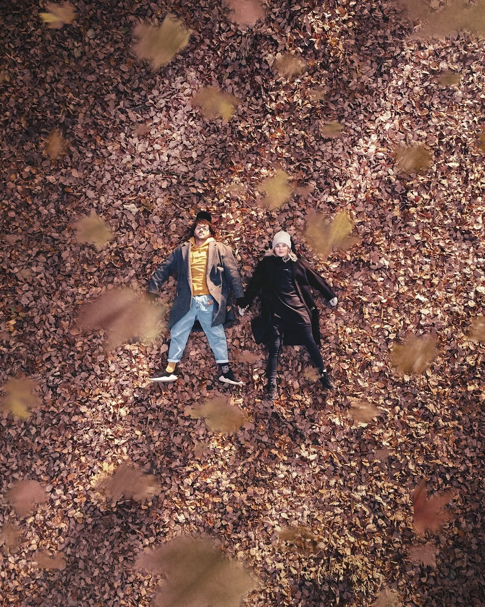 a couple of people that are standing in the leaves