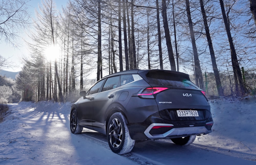 Un'auto nera che percorre una strada innevata