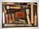 An assortment of leatherworking tools neatly arranged on a cutting mat. The collection includes tools such as hammers, awls, chisels, a cutting knife, and a steel ruler. A mid-sized leather wallet lies in the center amidst the tools, and various leather punches with wooden and metal handles are also present. The items are organized to display a variety of materials used in leather crafting.