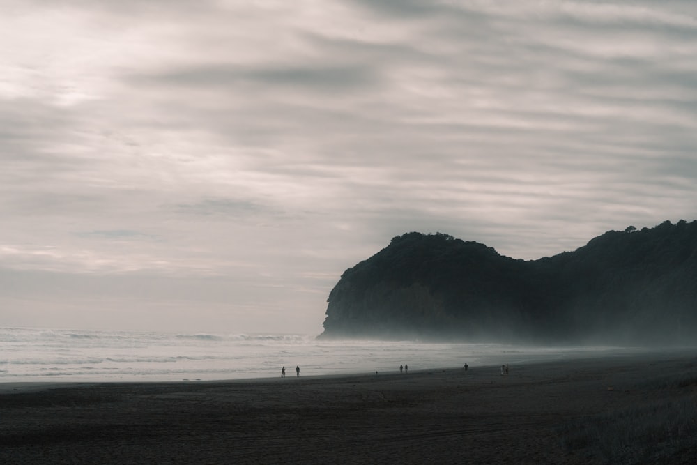 a group of people standing on top of a sandy beach