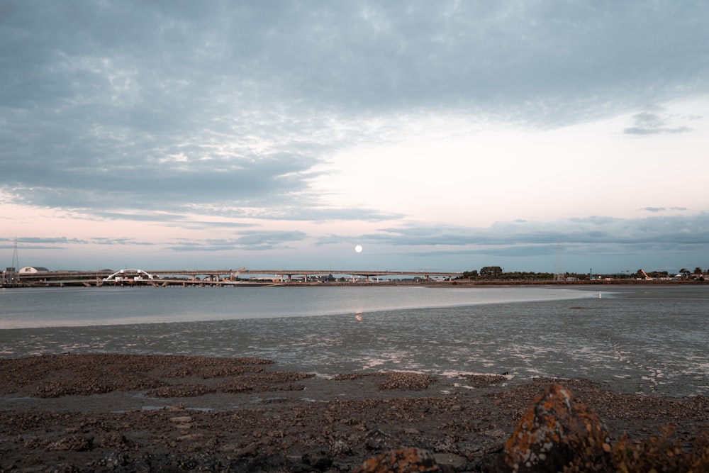 a body of water with a bridge in the background