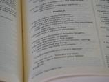 Open book displaying printed text, specifically a passage from a psalm, with a focus on neat typography and verses marked in sequence. The book is laid out on a flat surface with visible binding.